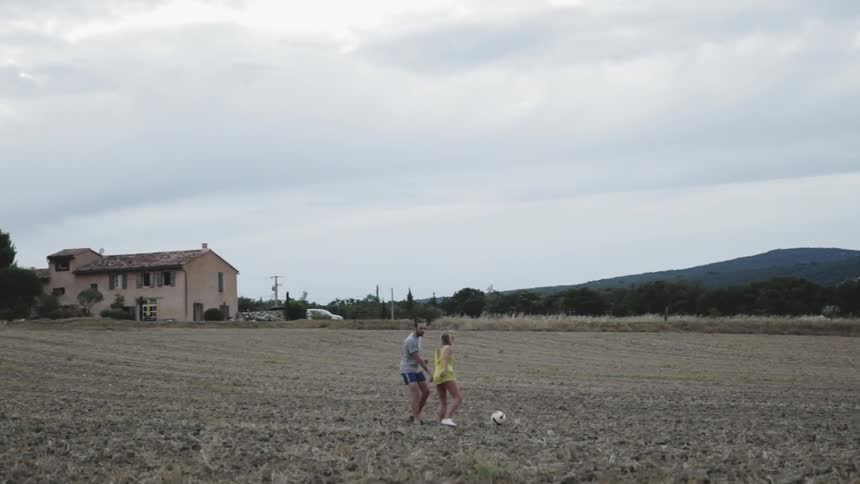 Two people play soccer on the large field