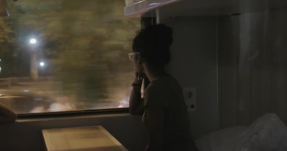 A woman looks out of the bus as it travels