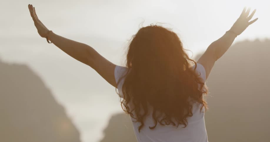 Child raises her arms in the sunlight