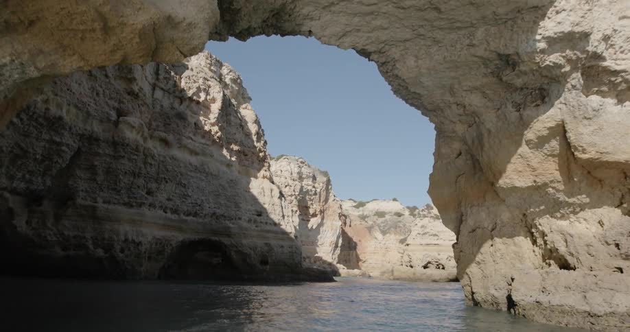 Traveling under arch in large rock formation in the ocean