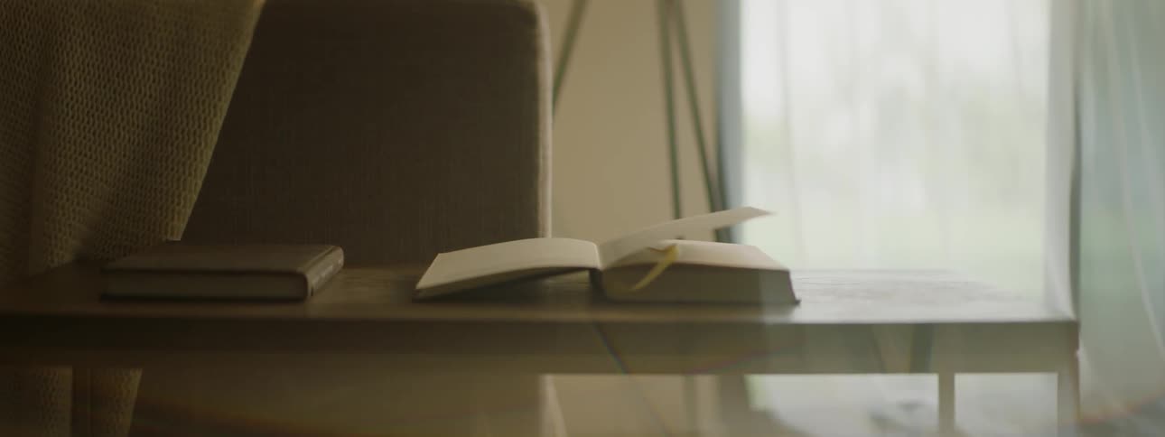 Pages of book on table are being blown and turned by the wind