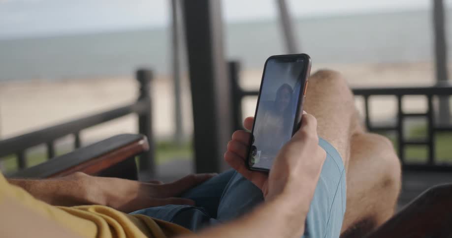 A person is sitting on the porch looking at a phone