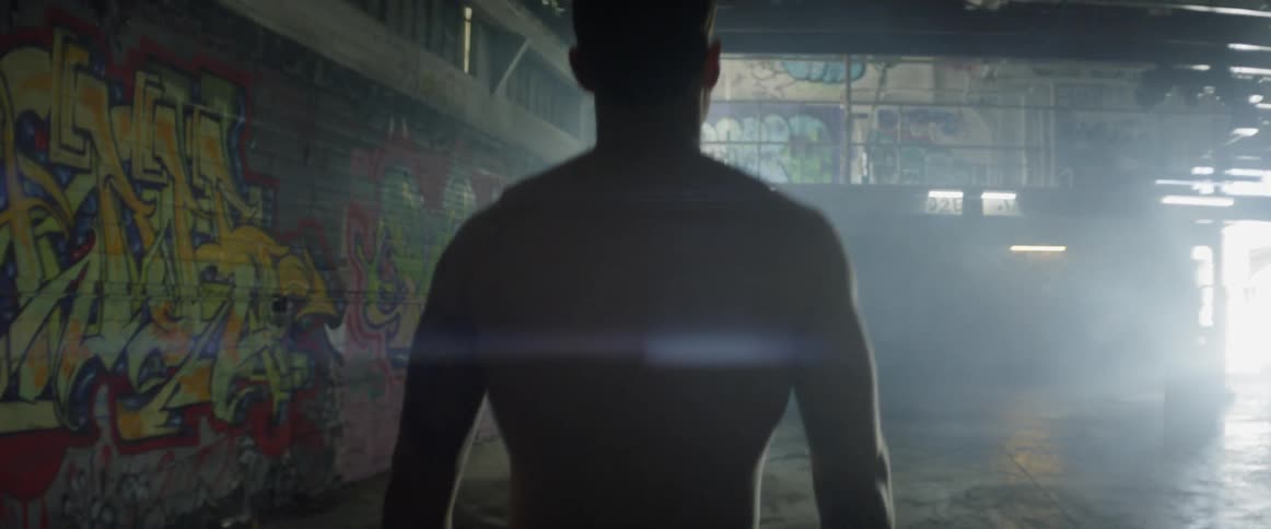 A man walks in the graffiti filled hall