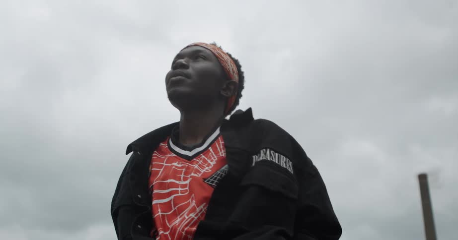 Man is standing outside looking at the cloudy sky
