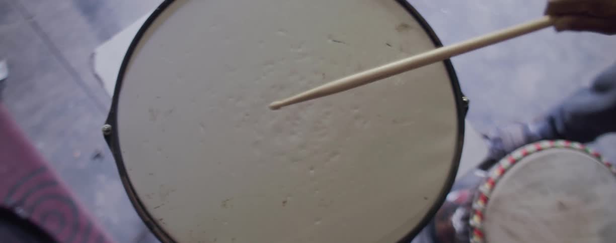 A drumstick hits a drumhead