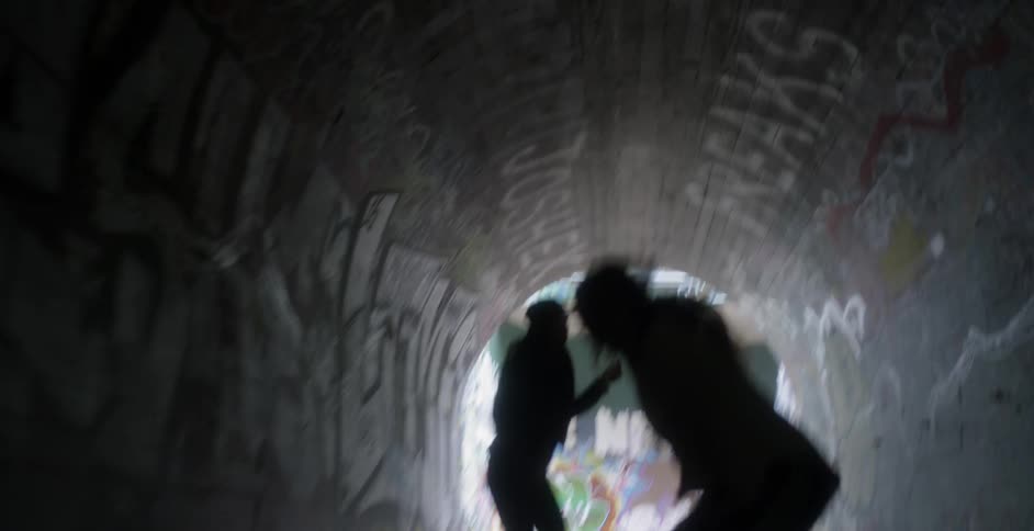 Two women dance in a tunnel