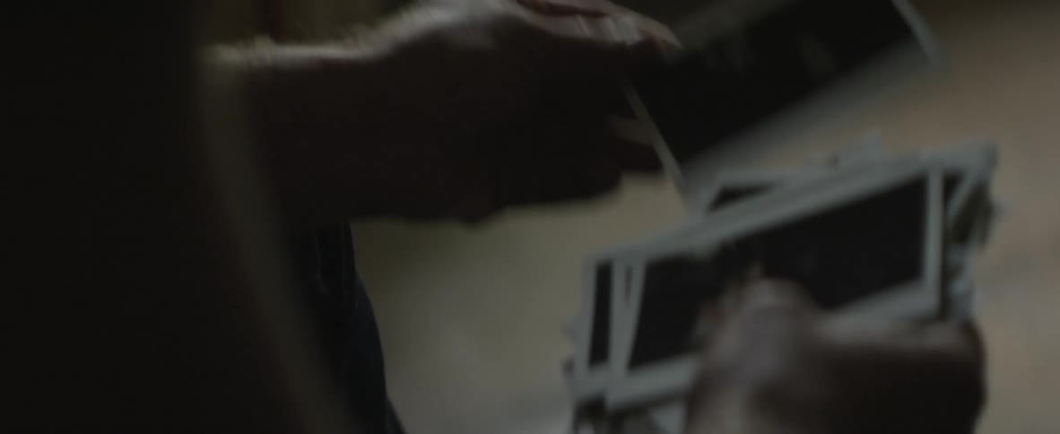 Person flipping through a pile of photographs