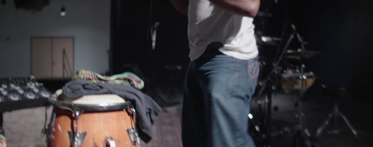 Man in rehearsal studio grabs cable