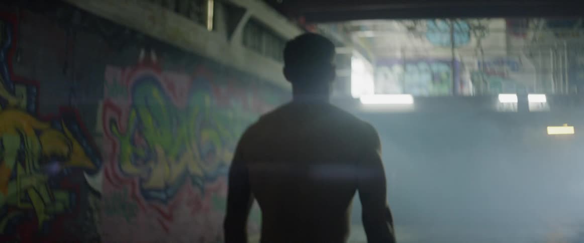 Shirtless man walks in an abandoned building