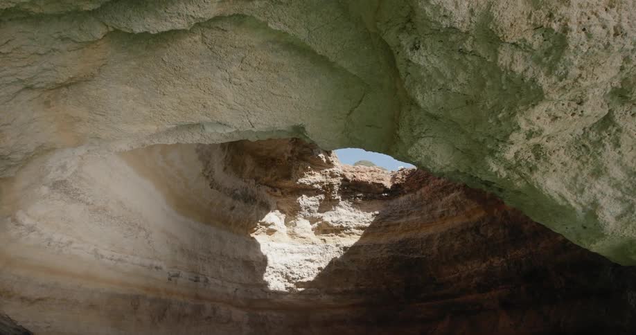 The sun shines through a cavern in the water