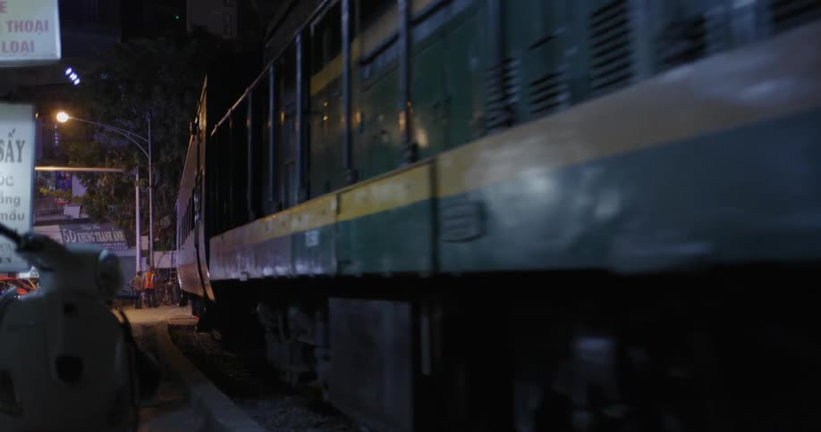 A train travels through a city at night