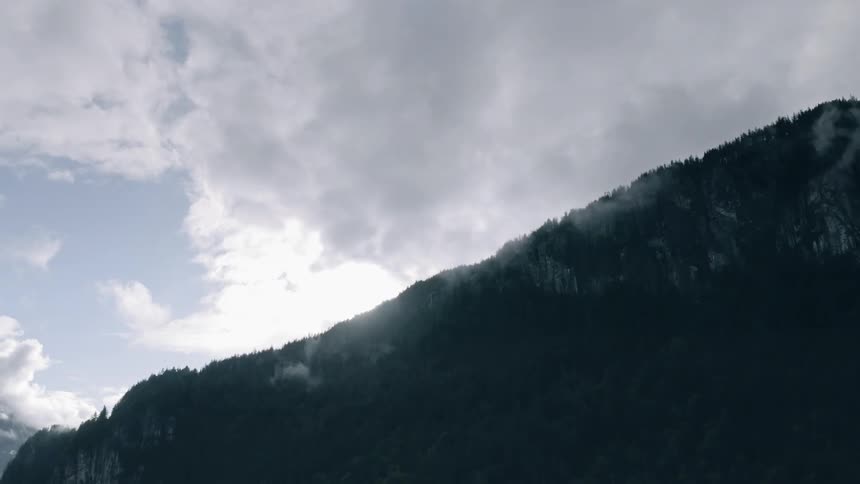 Clouds hang above the tall mountain