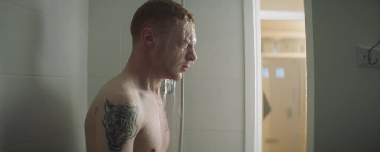 A man is taking a shower in his bathroom