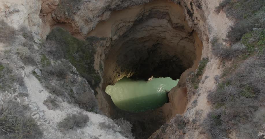 Water splashes below an opening in a cave