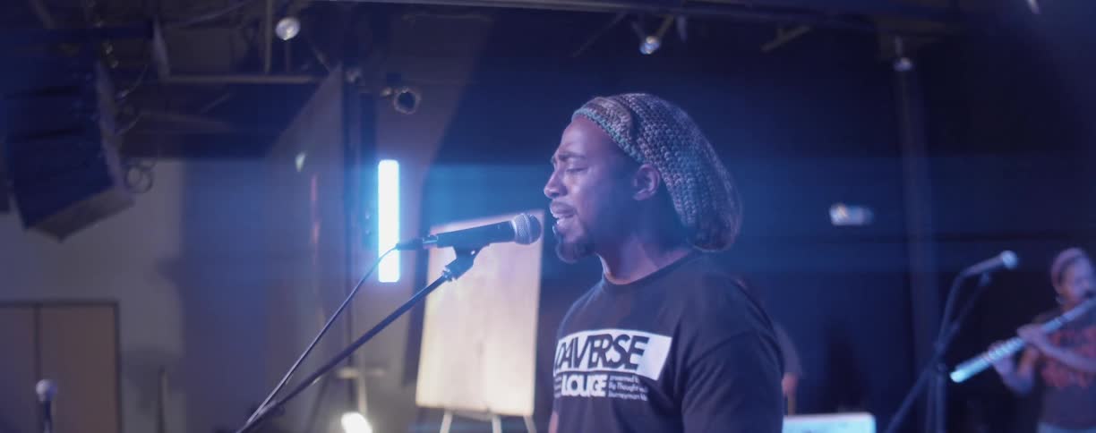 A man sings on stage at a concert hall
