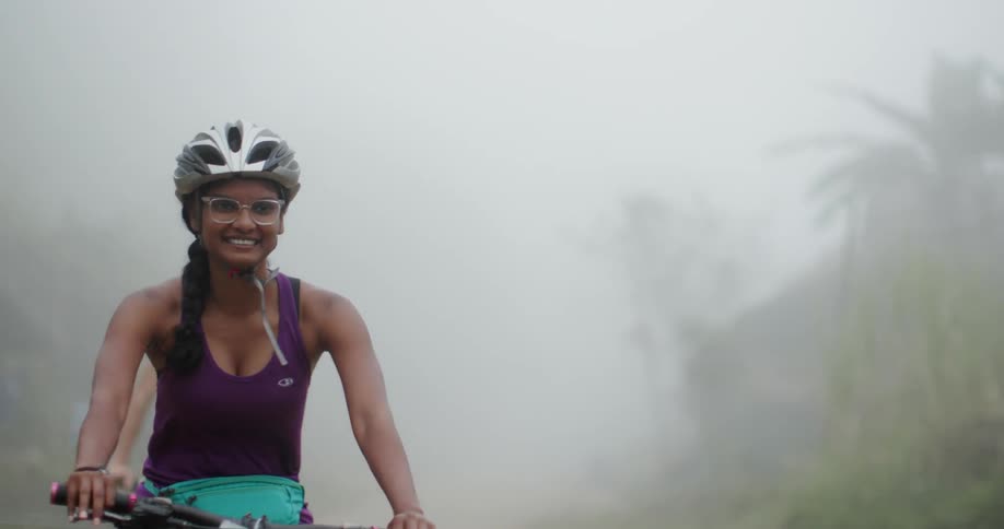 Group of people are smiling while riding bicycles in the fog