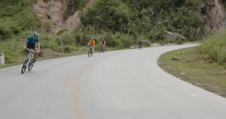 Bicyclists ride on a mountain road