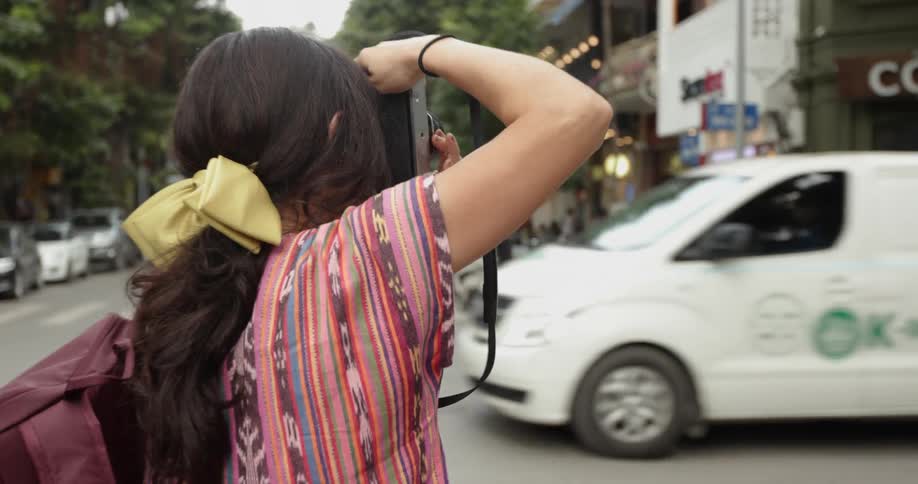 A woman takes photographs on the street