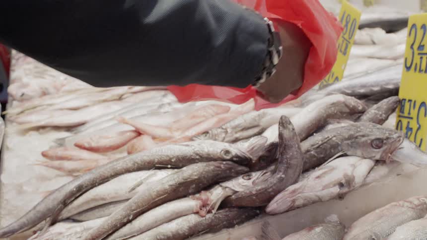 A man picks up some fish at the market