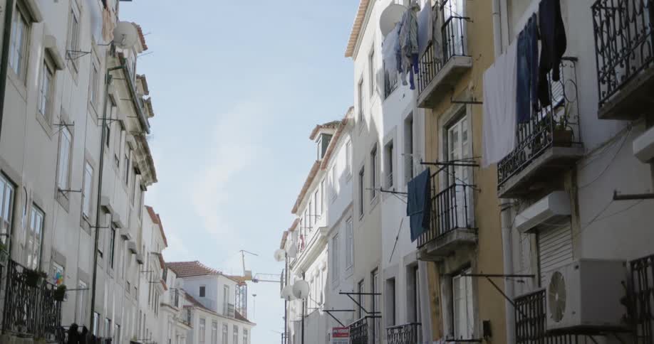 Clothes hang from balcony railings under a blue sky