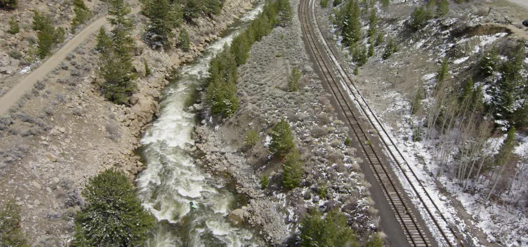 A person kayaks on a mountain river