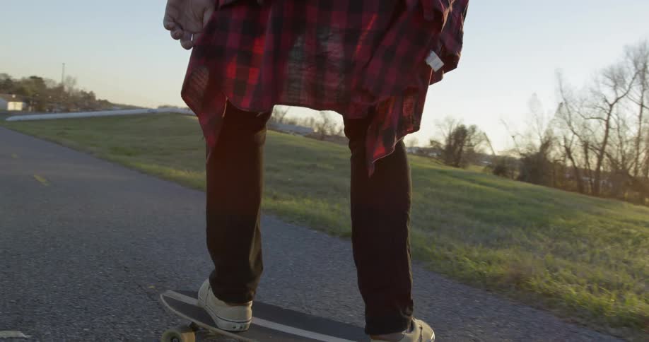 Person skateboarding in park at sunset
