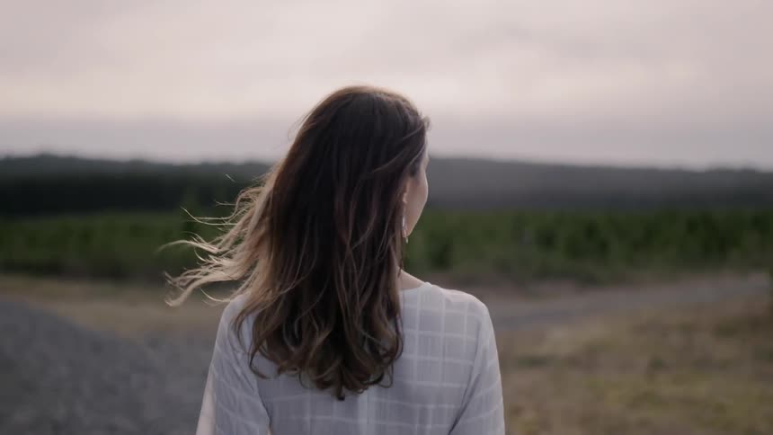 Woman walks on a rural road at sunset