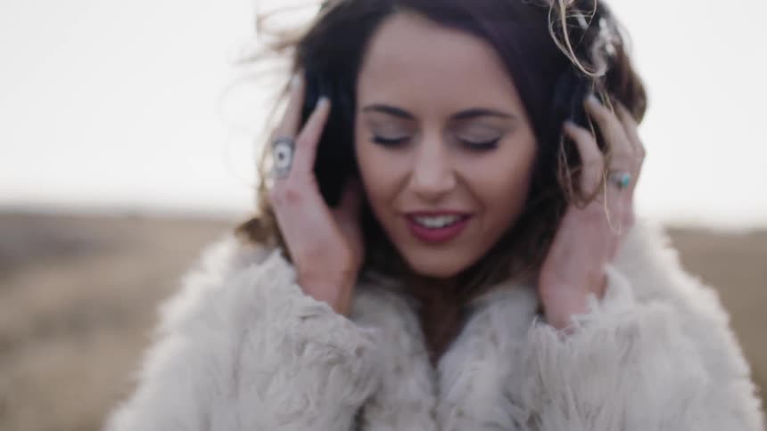 A woman listens to music on headphones