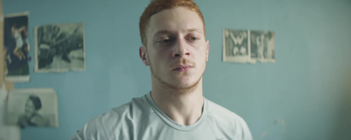 Man stands in a room in front of a blue wall