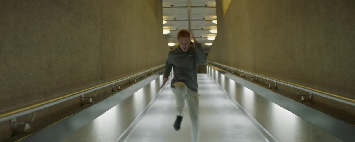 A male athlete is sprinting in place inside a hallway