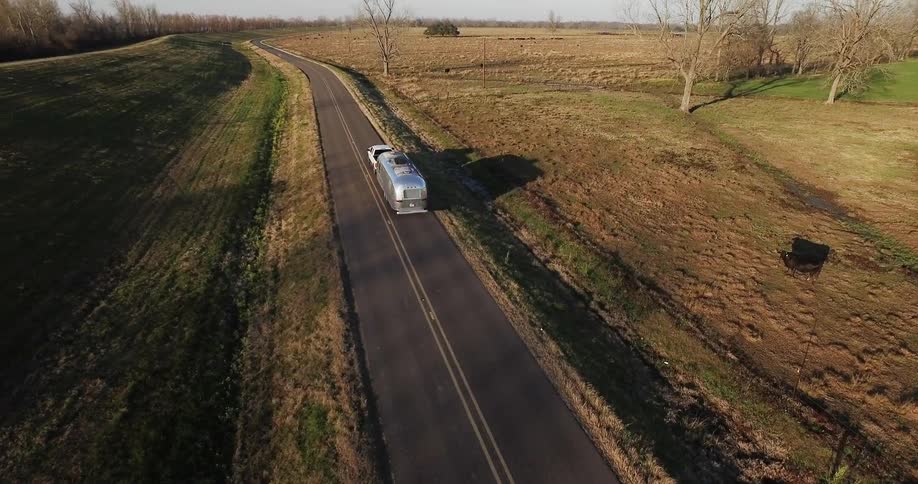 Truck pulls a trailer on a rural road