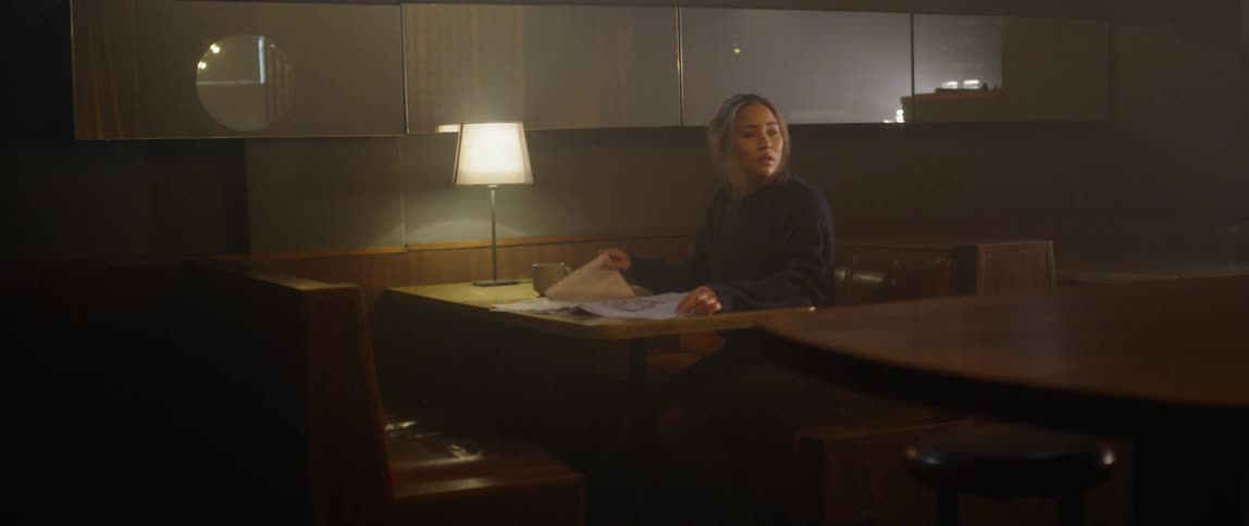 Woman reads a newspaper in a diner