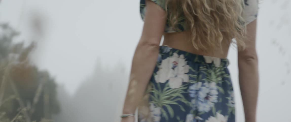 Woman walks in a field on a sunny day