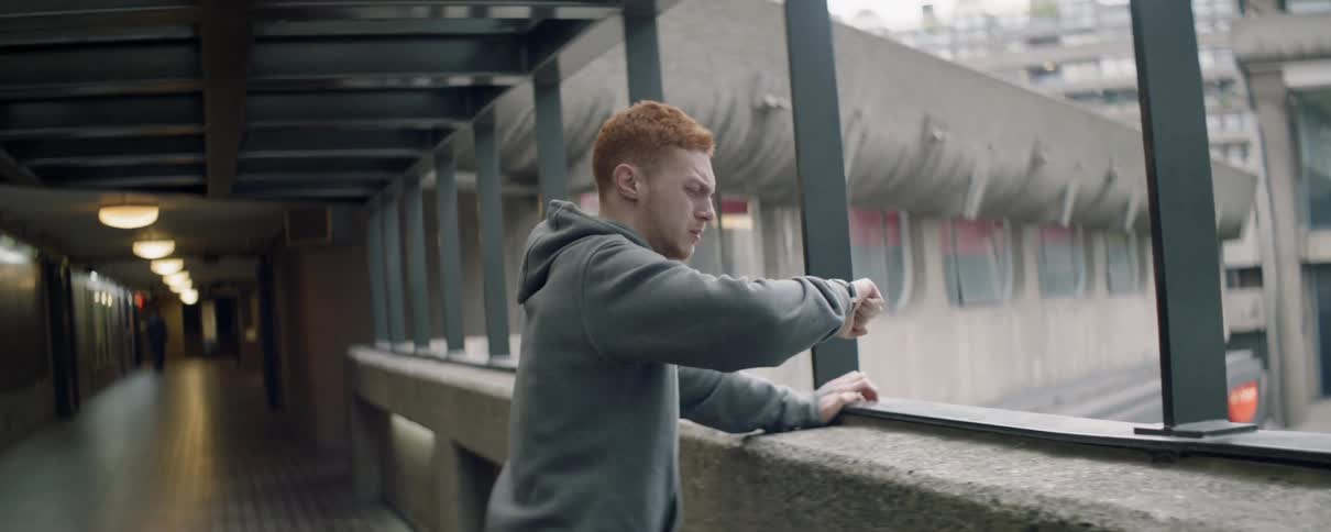 A man checks his watch and punches the railing