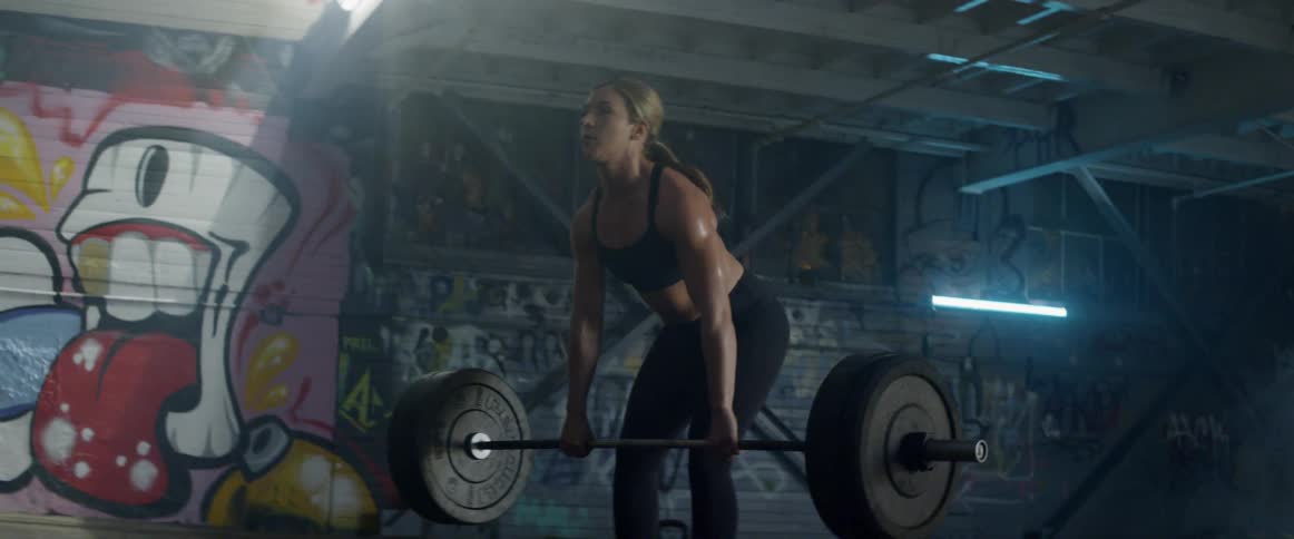 A woman lifts weights in a gym