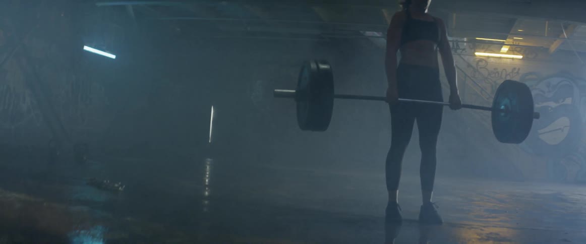 A woman lifts weights in a gym