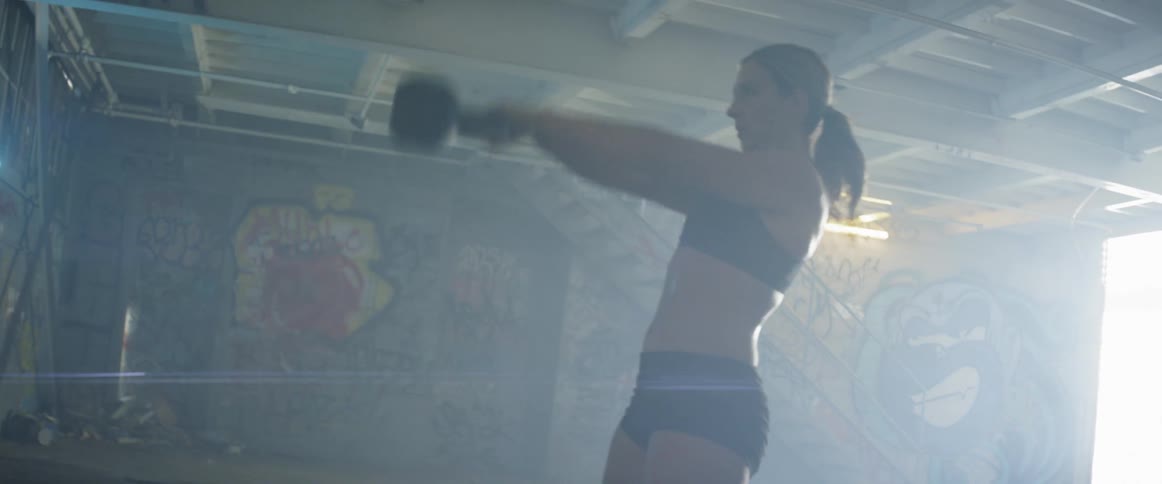 A man and woman exercise with kettlebells