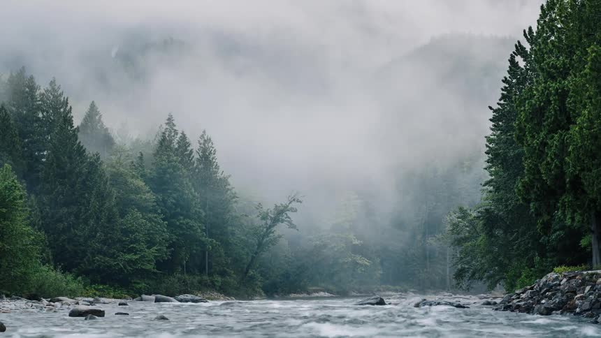 The clouds roll over the mountain by the stream - 4K Time Lapse