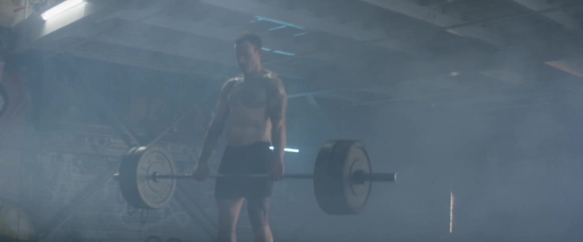 A man lifts weights in a gym