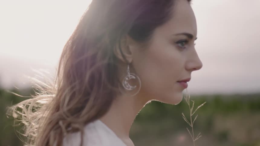 Woman stands in a field on a sunny day