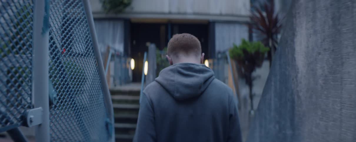 The man slowly walks over to the staircase