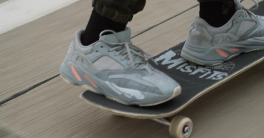 A person is riding on a skateboard on the sidewalk