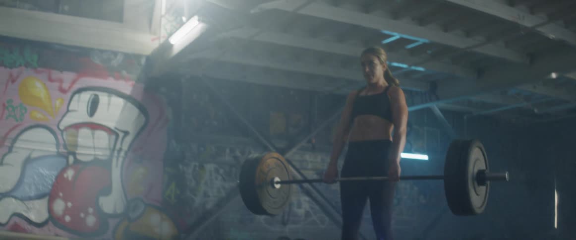 A woman lifts a heavy weight then drops it