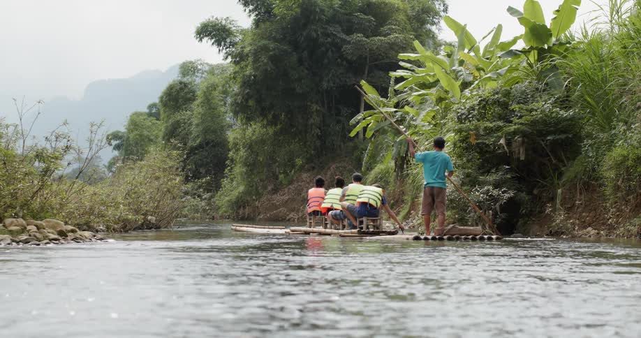 A man paddles a makeshift raft