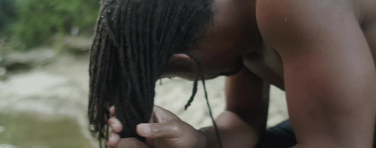 Man squeezes water out of dreadlocks