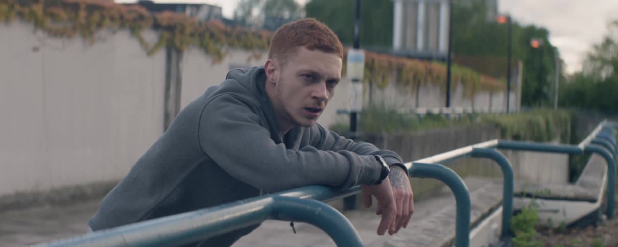 A man leans against the railing as he breathes heavy
