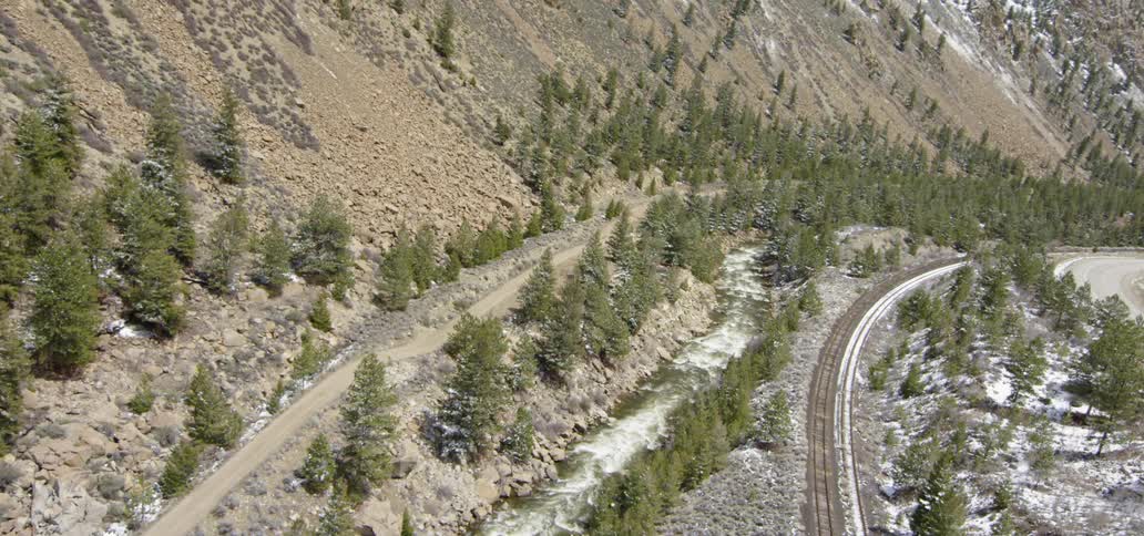 An empty road sits at the base of a hill