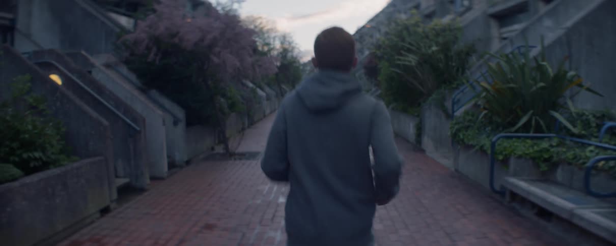 A man is jogging past apartment buildings