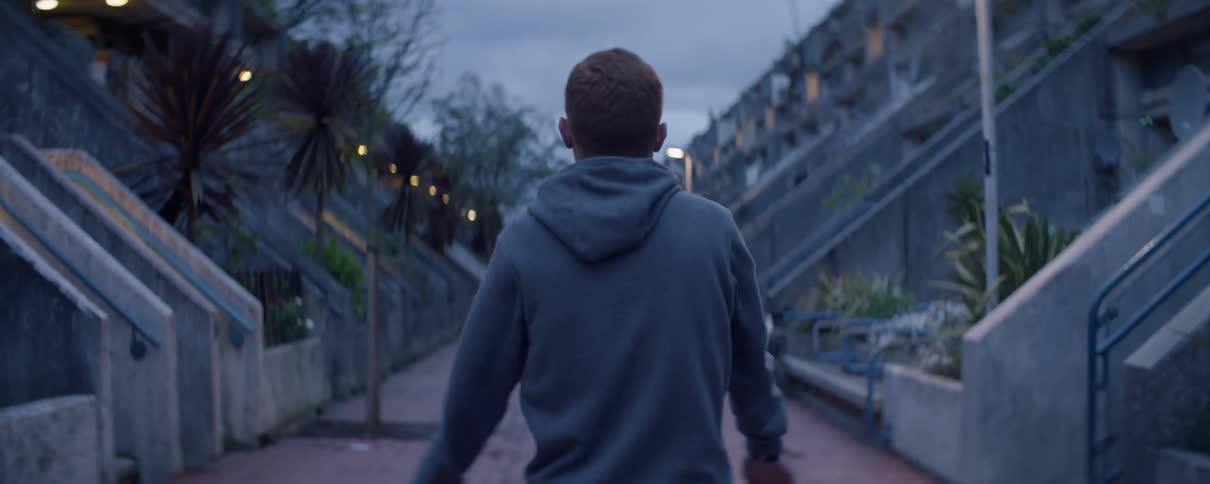 Man stretches his arms on a city sidewalk