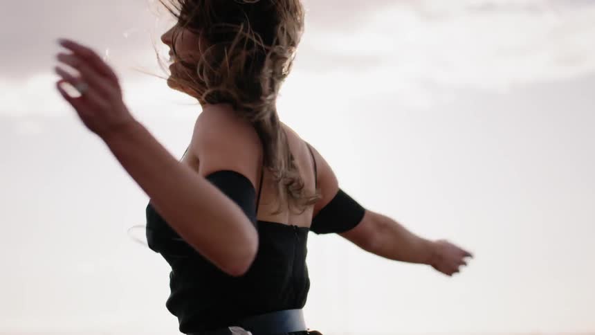 A woman spins and dances in the wind